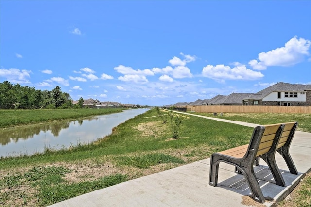 exterior space featuring a water view and fence