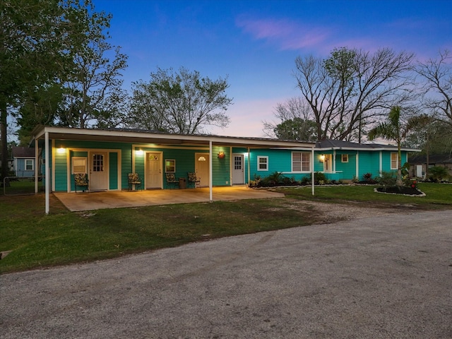 view of front of home with a front lawn, driveway, and a carport