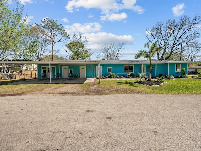 single story home featuring an attached carport and a front yard