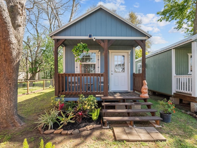 exterior space featuring a lawn, fence, and a porch