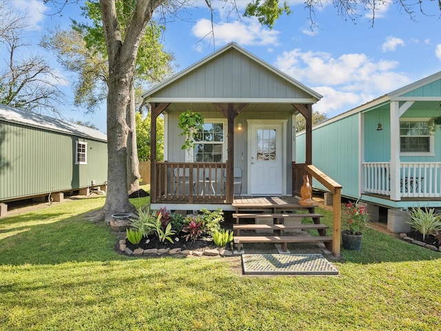 view of front of house featuring a front yard, an outdoor structure, and a porch