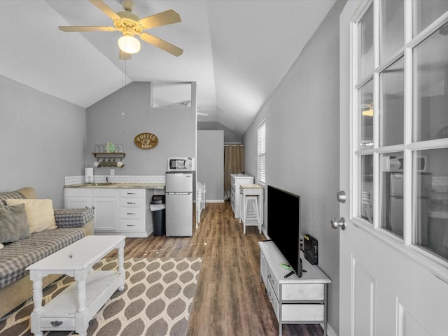 living room with lofted ceiling, ceiling fan, and wood finished floors