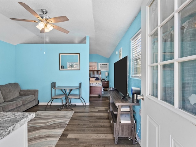 living room featuring a ceiling fan, wood finished floors, a textured ceiling, lofted ceiling, and baseboards