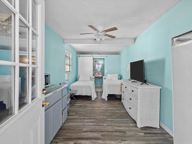 bedroom with a textured ceiling, ceiling fan, and dark wood finished floors