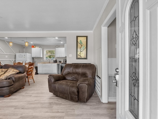 living area with light wood finished floors and ornamental molding