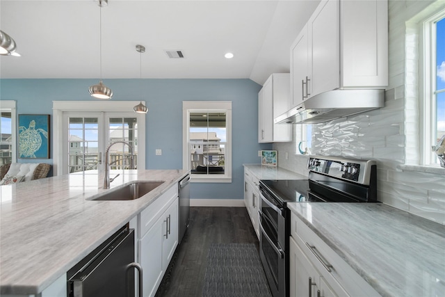 26711 Bay Water Dr, Galveston, TX 77554 - kitchen with white cabinetry, under cabinet range hood, a sink, stainless steel appliances, and backsplash