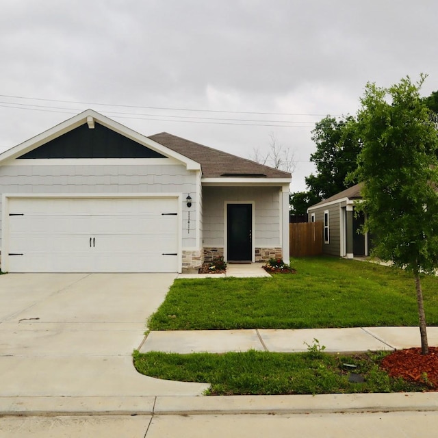 11411 Bright Sun Dr, Houston, TX 77048 - view of front of property with concrete driveway, stone siding, fence, a front yard, and a garage