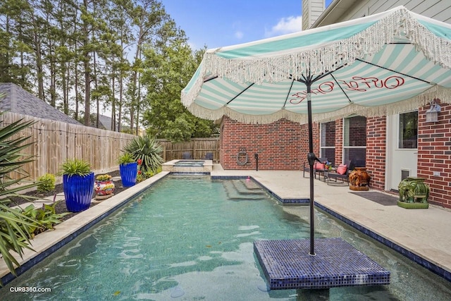 view of swimming pool featuring a patio, a pool with connected hot tub, and a fenced backyard