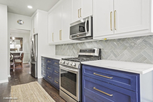 kitchen featuring stainless steel appliances, white cabinetry, blue cabinets, and backsplash