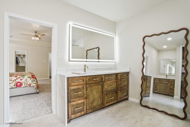 bathroom featuring ceiling fan, vanity, and baseboards