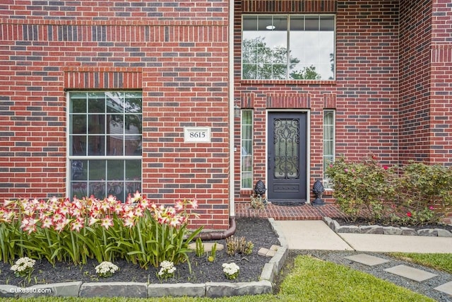 doorway to property with brick siding