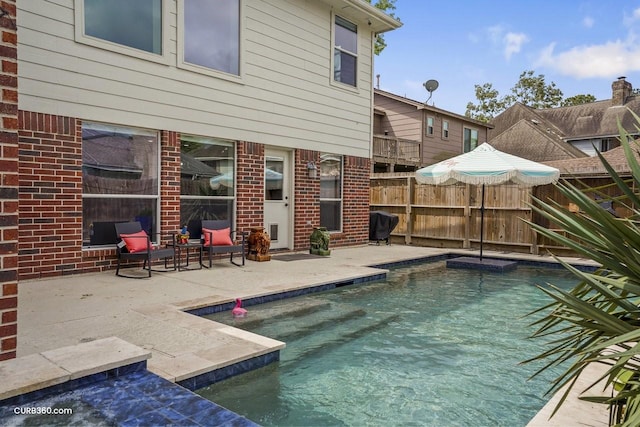 view of swimming pool featuring a patio area and fence