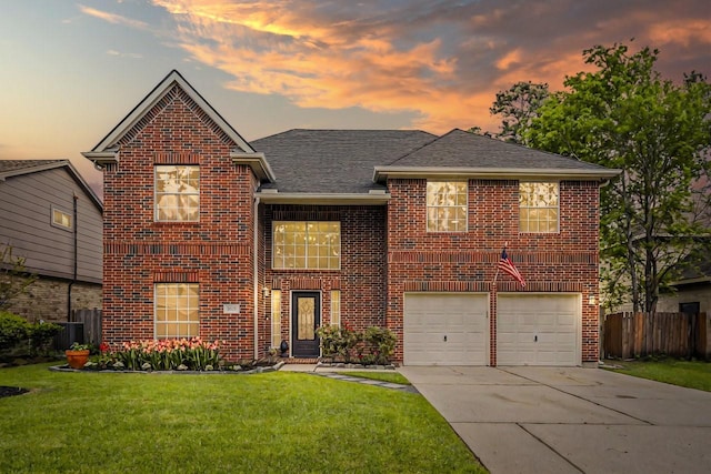 traditional home featuring a garage, a lawn, fence, brick siding, and driveway