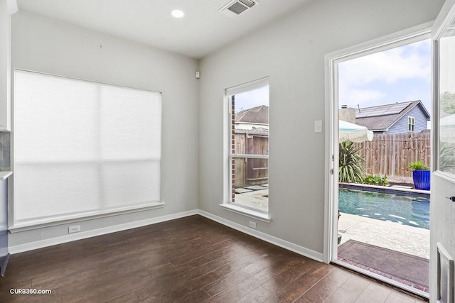 interior space with visible vents, baseboards, and wood finished floors
