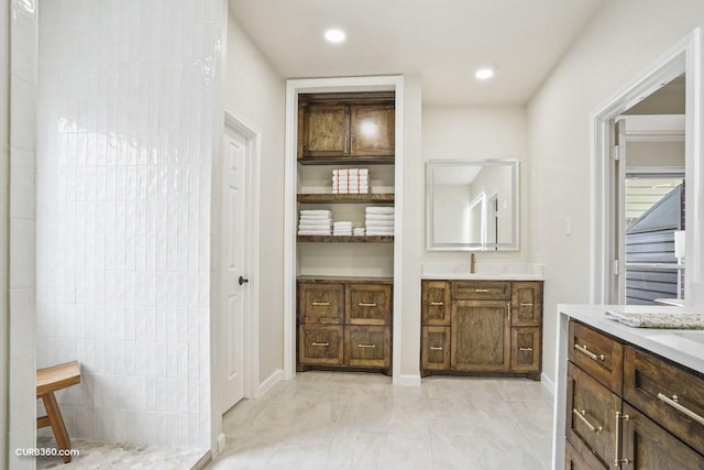 full bathroom with a walk in shower, recessed lighting, vanity, and baseboards