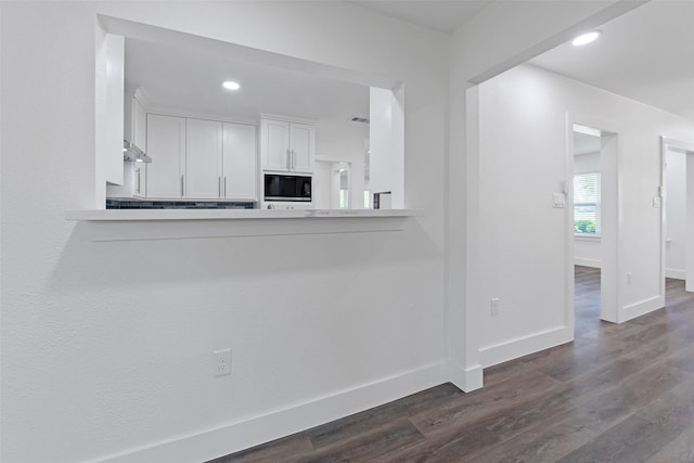 4074 Cheena Dr, Houston, TX 77025 - kitchen with black microwave, white cabinets, dark wood-style flooring, light countertops, and recessed lighting