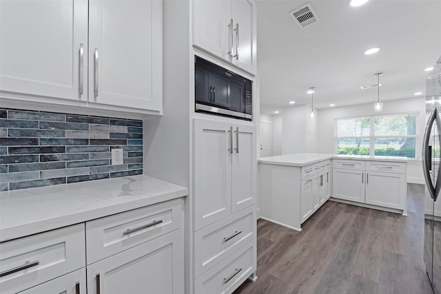 4074 Cheena Dr, Houston, TX 77025 - kitchen featuring black microwave, white cabinetry, dark wood finished floors, recessed lighting, and tasteful backsplash