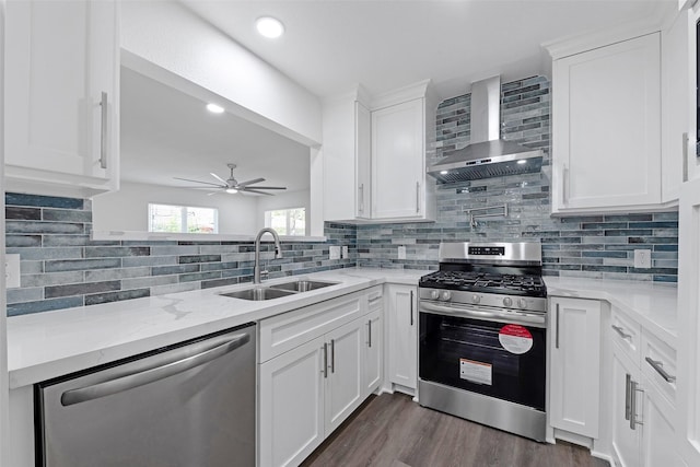 4074 Cheena Dr, Houston, TX 77025 - kitchen featuring wall chimney exhaust hood, appliances with stainless steel finishes, a sink, a ceiling fan, and backsplash