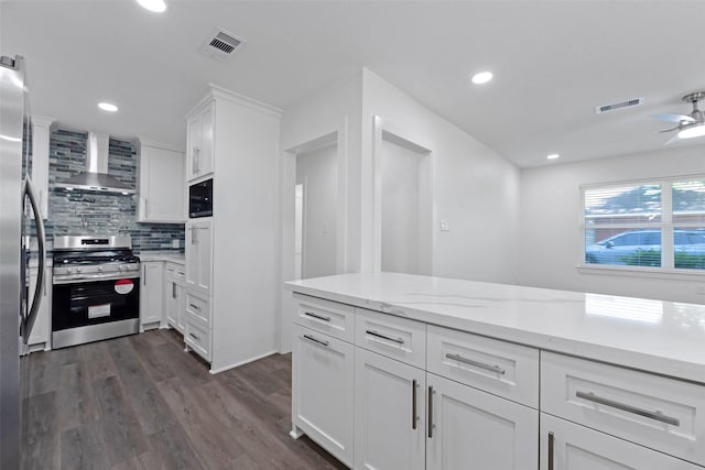 4074 Cheena Dr, Houston, TX 77025 - kitchen featuring wall chimney exhaust hood, gas range, ceiling fan, dark wood finished floors, and white cabinetry