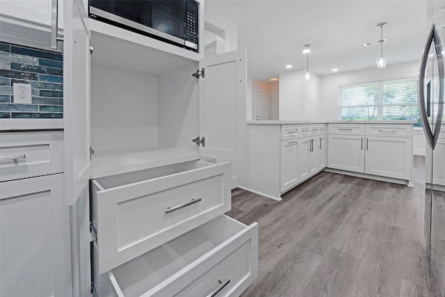 4074 Cheena Dr, Houston, TX 77025 - kitchen featuring white cabinets, light wood finished floors, recessed lighting, light countertops, and hanging light fixtures