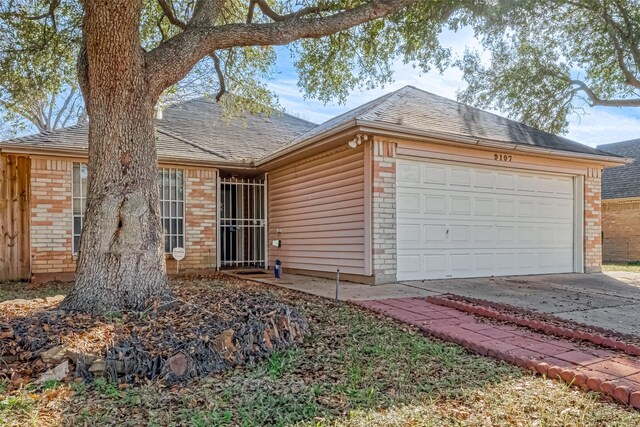 ranch-style house with brick siding, driveway, roof with shingles, and an attached garage