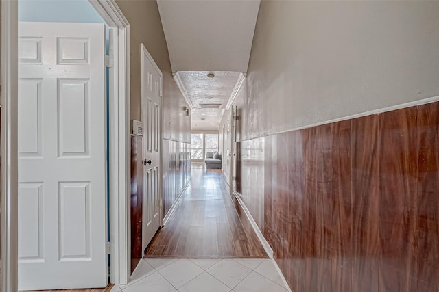 hall featuring tile patterned floors and a textured ceiling