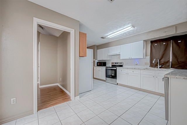 kitchen with white cabinetry, electric range, a sink, freestanding refrigerator, and black microwave