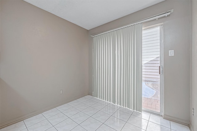 empty room featuring baseboards and light tile patterned floors