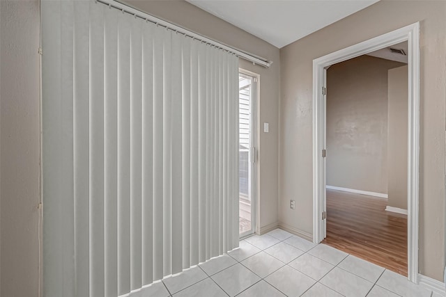 spare room with light tile patterned floors and baseboards