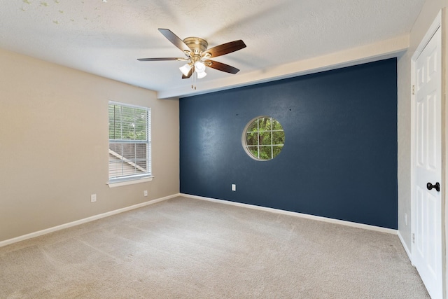 empty room with ceiling fan, baseboards, a textured ceiling, and carpet floors