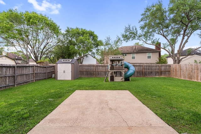 view of yard featuring a patio, an outdoor structure, a fenced backyard, a playground, and a storage unit