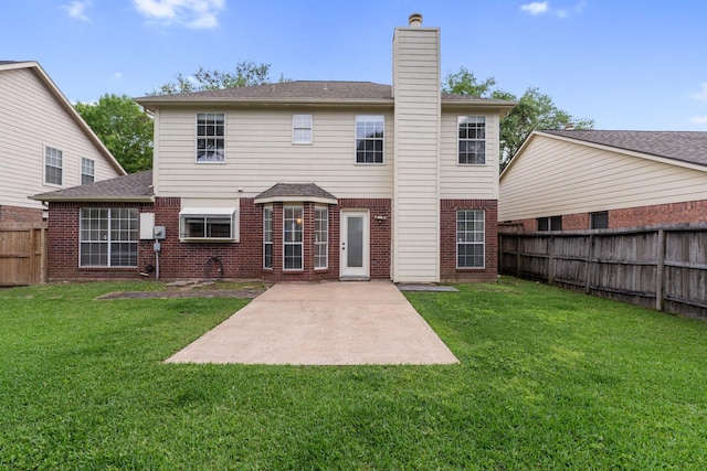 rear view of property with a yard, a patio area, a fenced backyard, and brick siding
