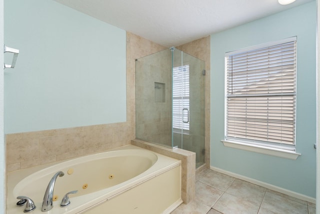 full bathroom featuring a shower stall, a jetted tub, baseboards, and tile patterned flooring