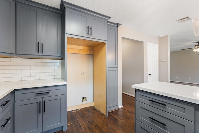 kitchen with visible vents, dark wood-style flooring, light countertops, a ceiling fan, and gray cabinets