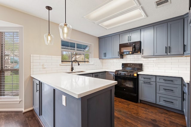 kitchen featuring a peninsula, black appliances, gray cabinetry, visible vents, and a sink