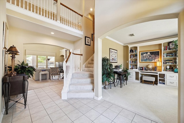 1314 Cross Valley Dr, Sugar Land, TX 77479 - tiled foyer entrance featuring arched walkways, carpet, stairway, ornamental molding, and a towering ceiling