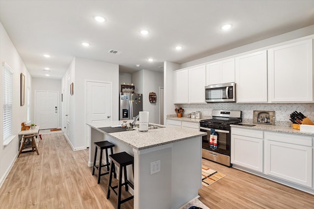 800 Westpointe Dr, Dayton, TX 77535 - kitchen with a sink, visible vents, light wood-style floors, and appliances with stainless steel finishes