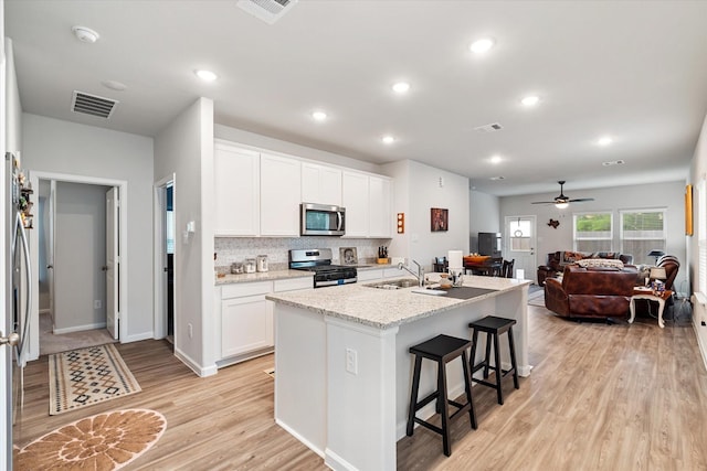 800 Westpointe Dr, Dayton, TX 77535 - kitchen with a kitchen breakfast bar, appliances with stainless steel finishes, light wood-style floors, and visible vents