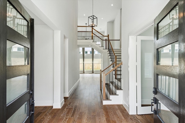 entrance foyer with stairway, wood finished floors, an inviting chandelier, baseboards, and recessed lighting