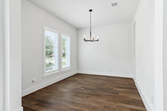 unfurnished room featuring dark wood-style floors, an inviting chandelier, visible vents, and baseboards
