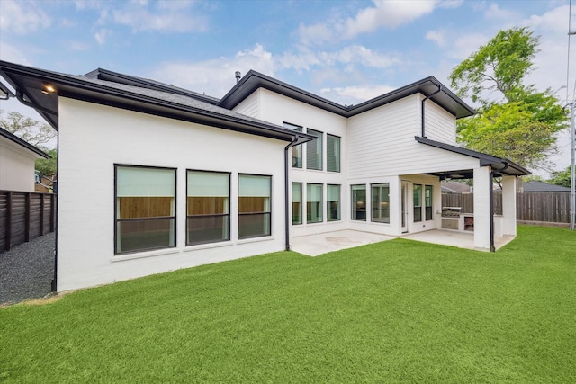 back of property with a yard, a patio area, a fenced backyard, and stucco siding