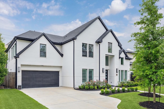 modern farmhouse style home featuring a garage, a front yard, stucco siding, and fence