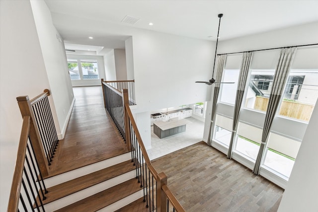 stairs with a ceiling fan, wood finished floors, baseboards, visible vents, and recessed lighting