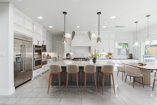 626 Attingham Dr, Houston, TX 77024 - kitchen featuring appliances with stainless steel finishes, custom range hood, backsplash, recessed lighting, and white cabinetry