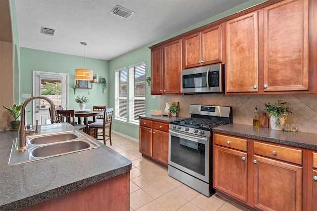 9330 Vander Rock Dr, Houston, TX 77095 - kitchen with visible vents, stainless steel appliances, dark countertops, and a sink