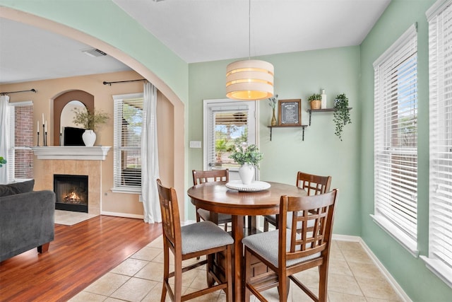 9330 Vander Rock Dr, Houston, TX 77095 - dining room featuring light tile patterned floors, visible vents, baseboards, and a fireplace