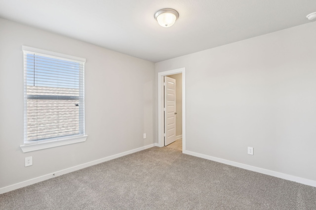 empty room with baseboards and light colored carpet