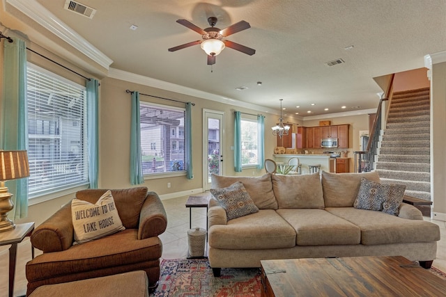 343 Old Aqua Lndg E, Conroe, TX 77356 - living room with ceiling fan with notable chandelier, visible vents, stairway, and ornamental molding