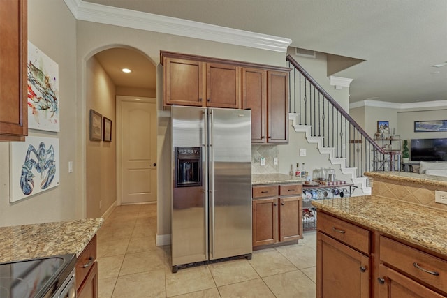 343 Old Aqua Lndg E, Conroe, TX 77356 - kitchen with stainless steel fridge with ice dispenser, light stone countertops, and brown cabinetry