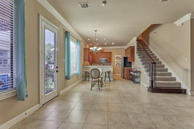 343 Old Aqua Lndg E, Conroe, TX 77356 - dining area with stairway, ornamental molding, light tile patterned flooring, visible vents, and a notable chandelier